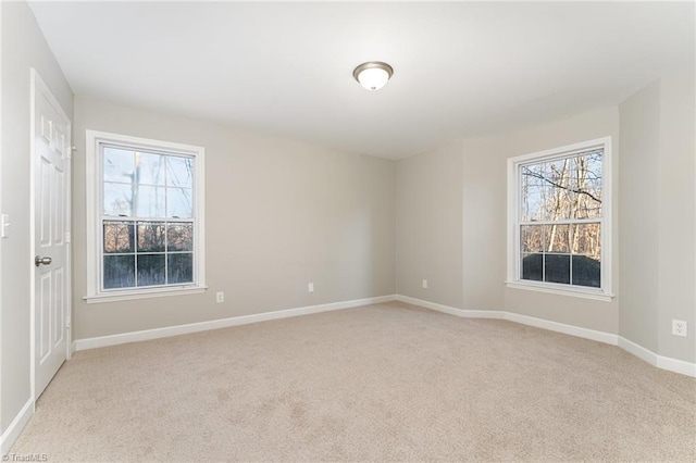 unfurnished room with light carpet and plenty of natural light