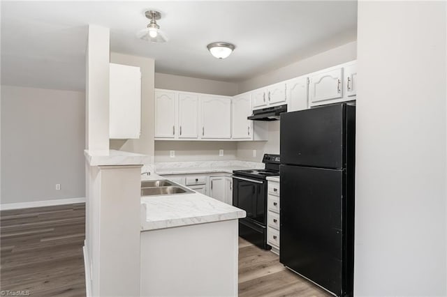 kitchen with black appliances, white cabinets, and kitchen peninsula