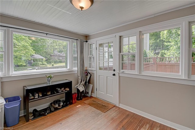 sunroom / solarium featuring wood finished floors, baseboards, and a deck