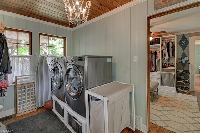 laundry area with separate washer and dryer, wooden ceiling, crown molding, a chandelier, and wood finished floors