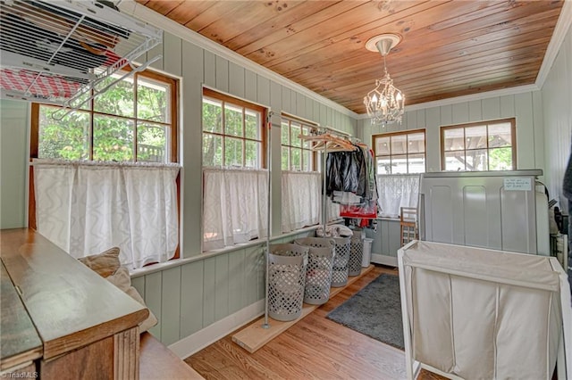interior space with wood ceiling, crown molding, wood finished floors, and a chandelier