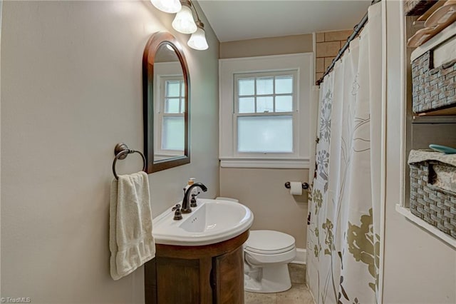 bathroom with toilet, tile patterned floors, vanity, and curtained shower