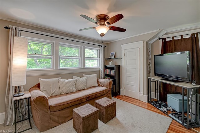 living room with ceiling fan, crown molding, light wood-style flooring, and baseboards