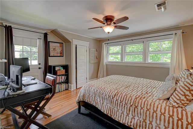 bedroom featuring wood finished floors, a ceiling fan, and a desk
