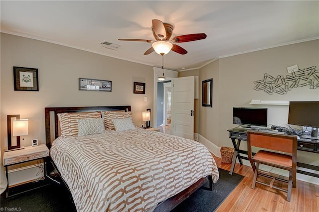 bedroom with wood finished floors, baseboards, crown molding, an office area, and a ceiling fan