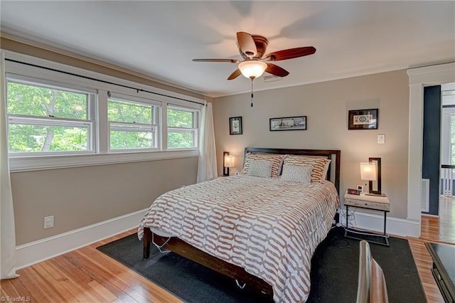 bedroom featuring wood finished floors, baseboards, and a ceiling fan
