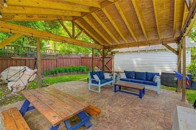 view of patio featuring an outdoor living space, a fenced backyard, and a gazebo