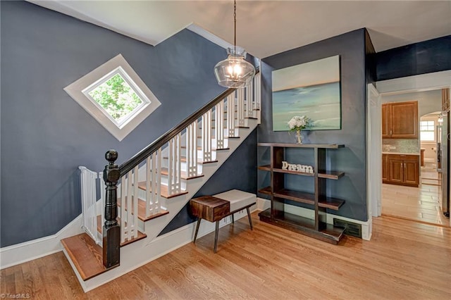 stairs featuring wood finished floors and baseboards