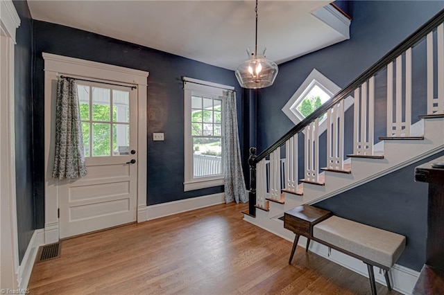 foyer featuring stairs, wood finished floors, and baseboards