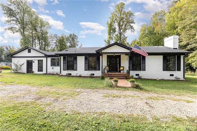 rear view of property featuring a lawn