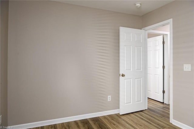 unfurnished room with wood finished floors and baseboards