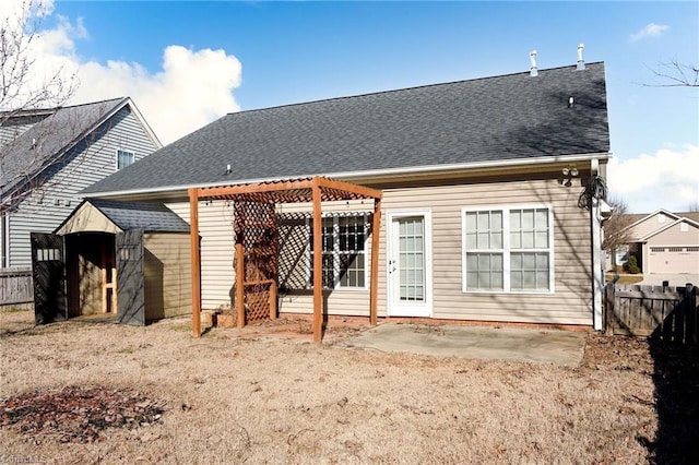 back of property with a shingled roof, a pergola, fence, and a patio