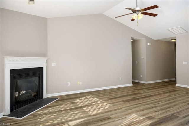 unfurnished living room with lofted ceiling, visible vents, wood finished floors, and a glass covered fireplace