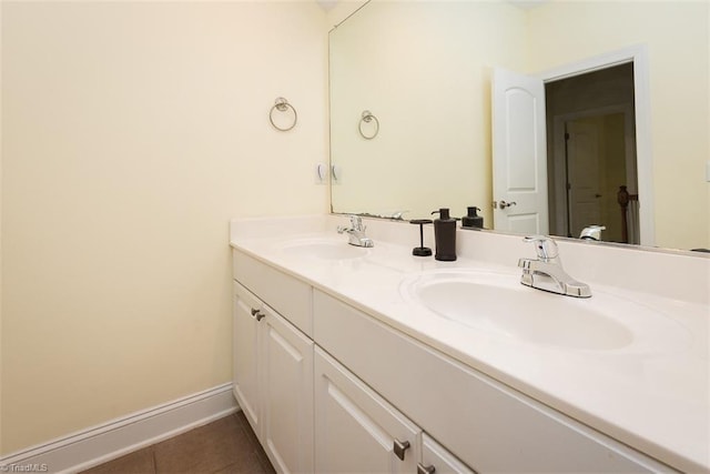 bathroom featuring double vanity, tile patterned flooring, baseboards, and a sink