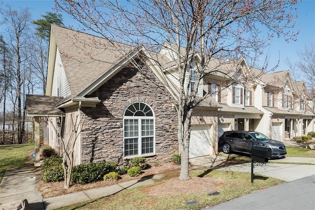 view of side of property with stone siding, roof with shingles, an attached garage, and concrete driveway