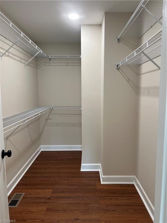 walk in closet featuring dark wood-style flooring and visible vents