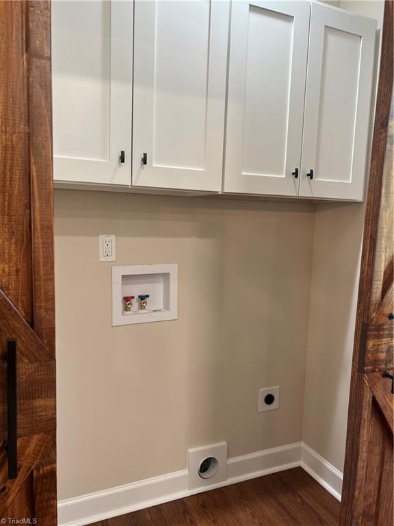 laundry area featuring dark wood-style flooring, washer hookup, baseboards, cabinet space, and electric dryer hookup