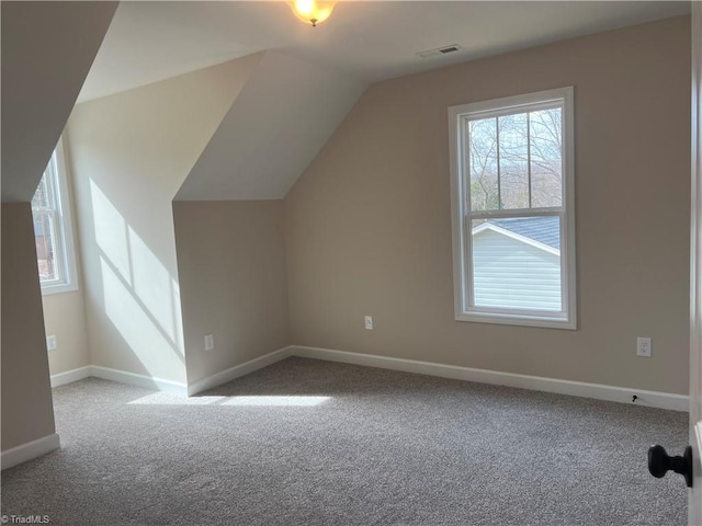 bonus room featuring lofted ceiling, baseboards, visible vents, and carpet flooring