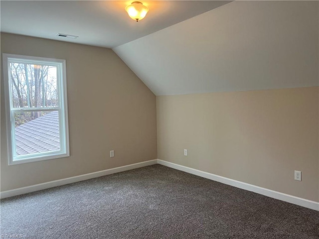 additional living space with lofted ceiling, carpet flooring, visible vents, and baseboards