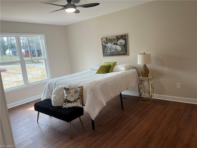 bedroom featuring dark wood-type flooring, visible vents, baseboards, and a ceiling fan