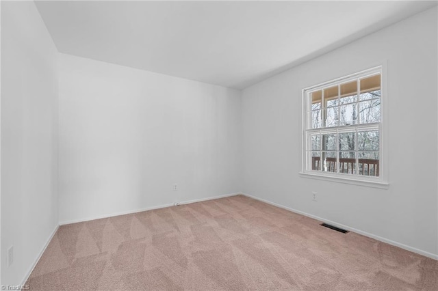 carpeted empty room with visible vents and baseboards