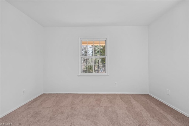 carpeted empty room featuring baseboards