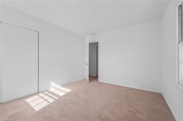 unfurnished room featuring carpet flooring and baseboards