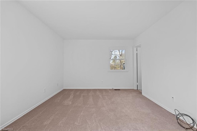 unfurnished room with baseboards and light carpet