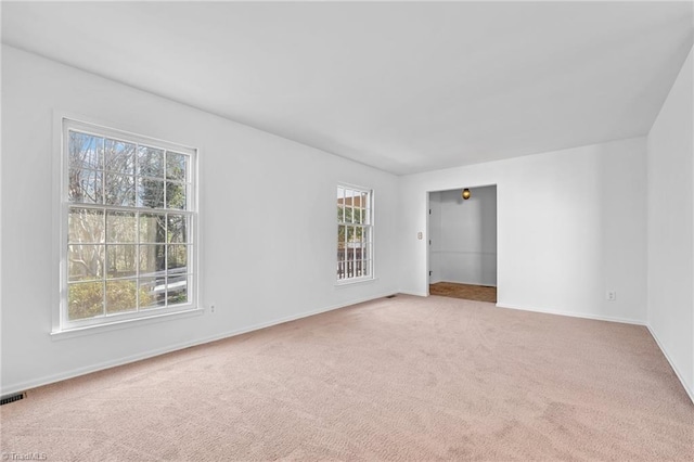 spare room featuring visible vents, baseboards, and carpet