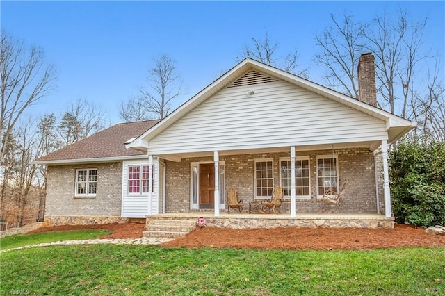 view of front of house with covered porch and a front lawn