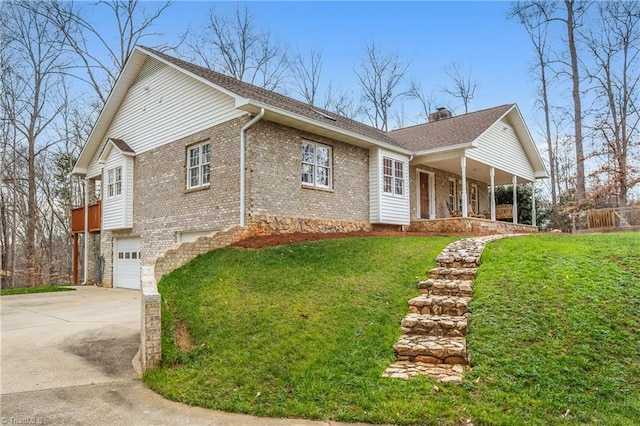 view of front of house featuring a front yard, a garage, and covered porch