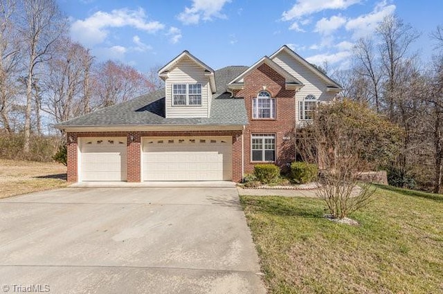 traditional-style house with concrete driveway, brick siding, an attached garage, and a front yard