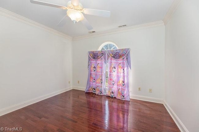 spare room with baseboards, visible vents, ceiling fan, ornamental molding, and wood finished floors