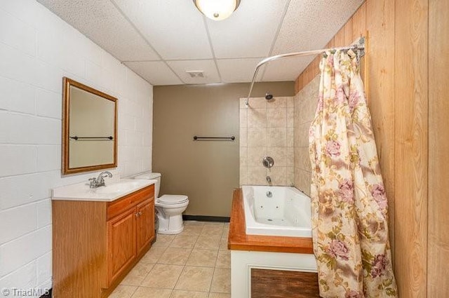 bathroom with a drop ceiling, toilet, shower / tub combo, vanity, and tile patterned floors