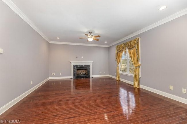 unfurnished living room with ornamental molding, a high end fireplace, a ceiling fan, wood finished floors, and baseboards