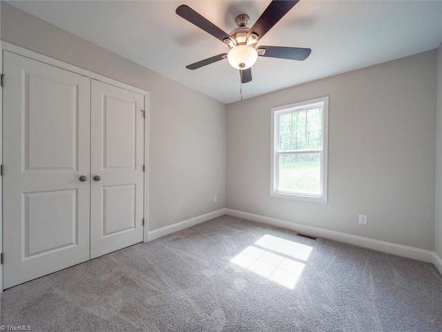 unfurnished bedroom featuring a closet, light carpet, and ceiling fan