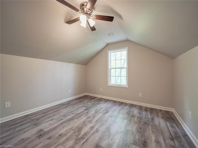 additional living space featuring hardwood / wood-style floors, vaulted ceiling, and ceiling fan