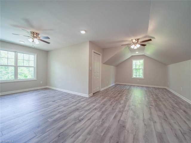 additional living space featuring light hardwood / wood-style flooring, ceiling fan, and lofted ceiling