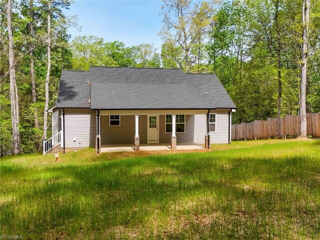 rear view of house with a patio and a lawn