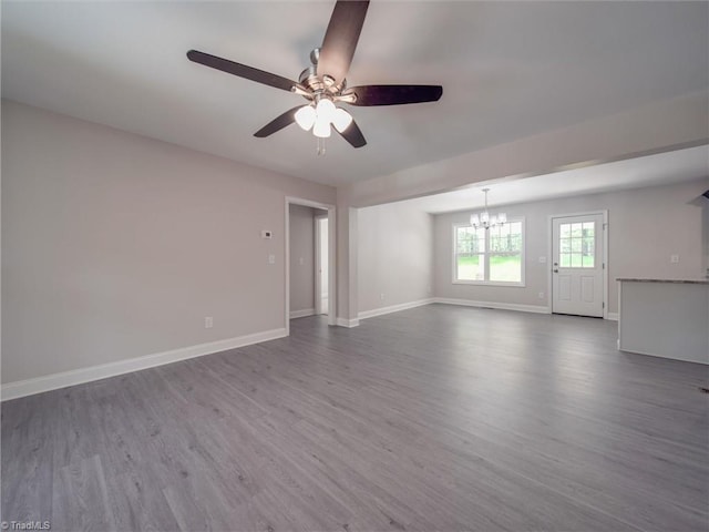 unfurnished room featuring ceiling fan with notable chandelier and dark hardwood / wood-style floors