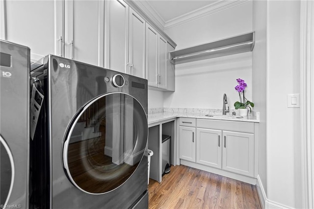 7604 Pemberley Dr, Oak Ridge, NC 27310 - laundry area with cabinet space, ornamental molding, light wood-style floors, and washing machine and clothes dryer