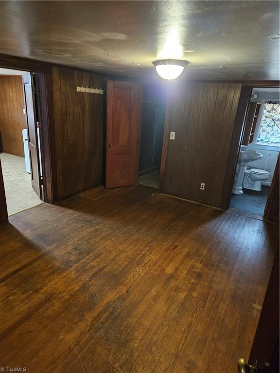 basement with dark wood-style floors and wooden walls