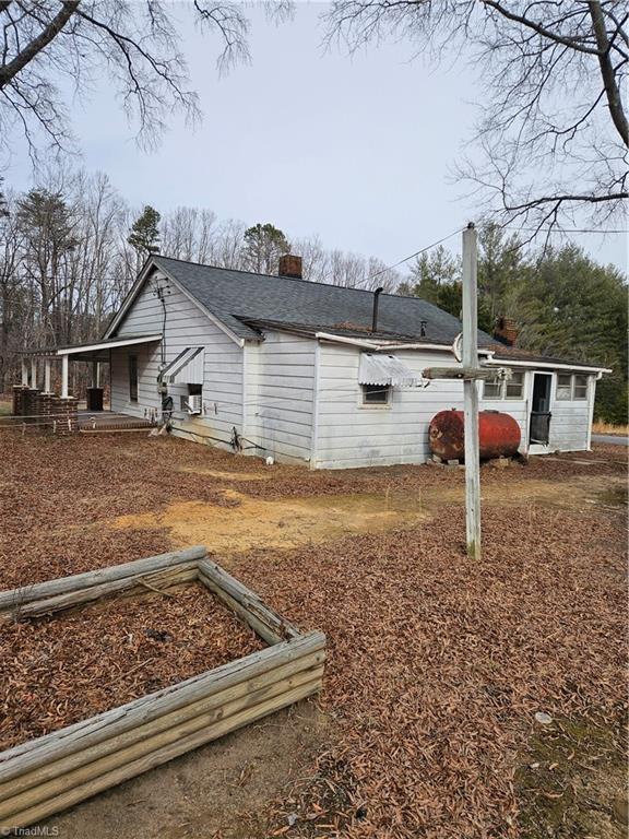 view of side of home featuring a chimney and a shingled roof