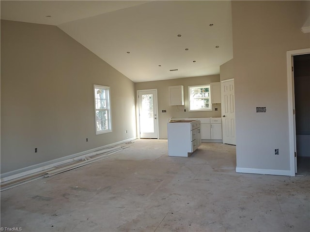 kitchen featuring white cabinets and high vaulted ceiling