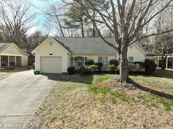 single story home with a garage, concrete driveway, and a front yard