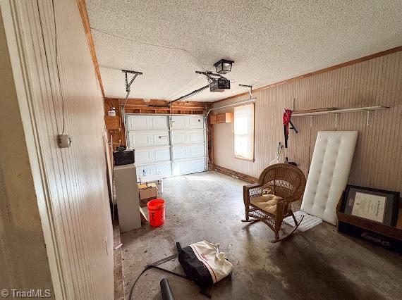 garage featuring wood walls and a garage door opener