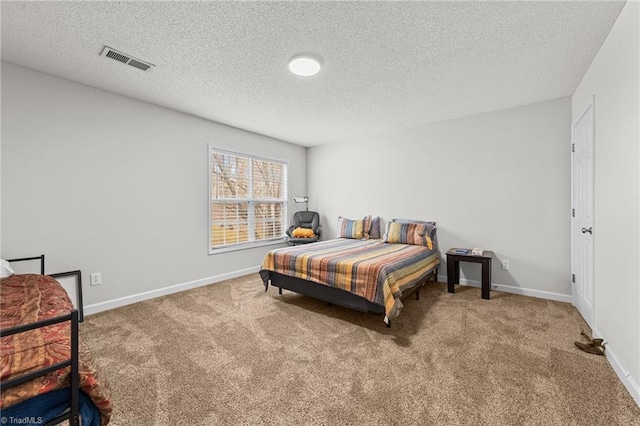 carpeted bedroom featuring baseboards, visible vents, and a textured ceiling