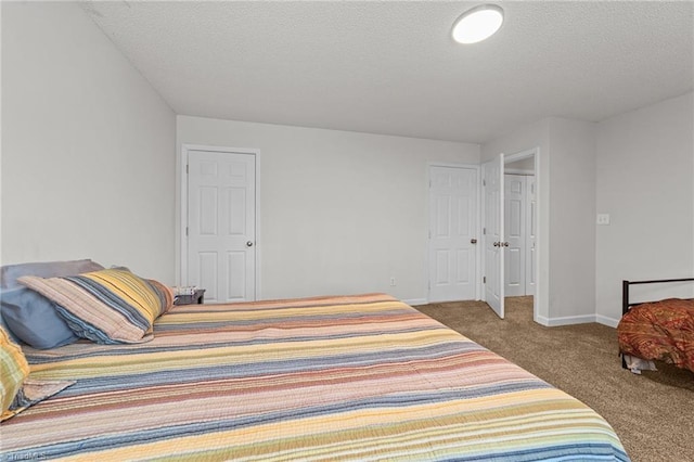 bedroom featuring baseboards, carpet, and a textured ceiling