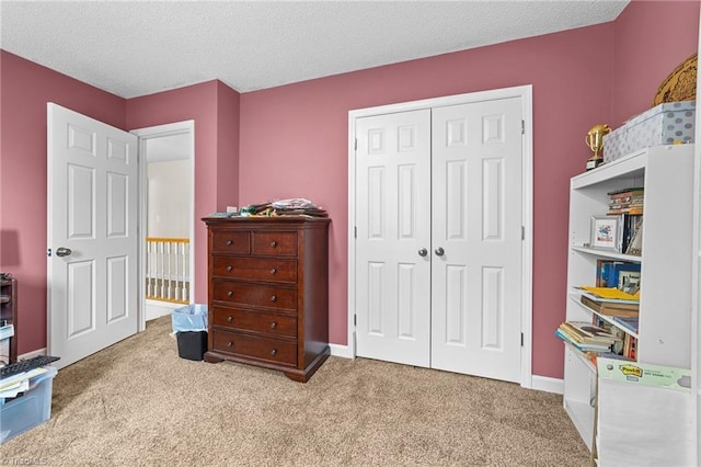 carpeted bedroom featuring baseboards, a closet, and a textured ceiling