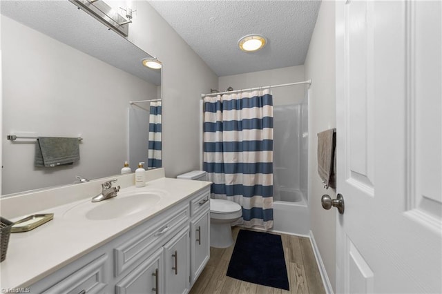 full bathroom featuring vanity, wood finished floors, shower / bath combination with curtain, a textured ceiling, and toilet